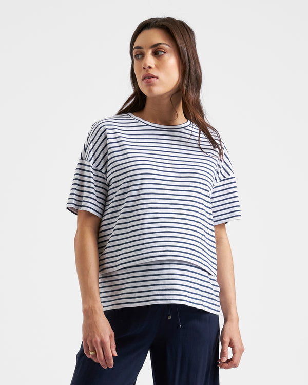 ||Pregnant woman wearing white and navy striped nursing tee on a plain background