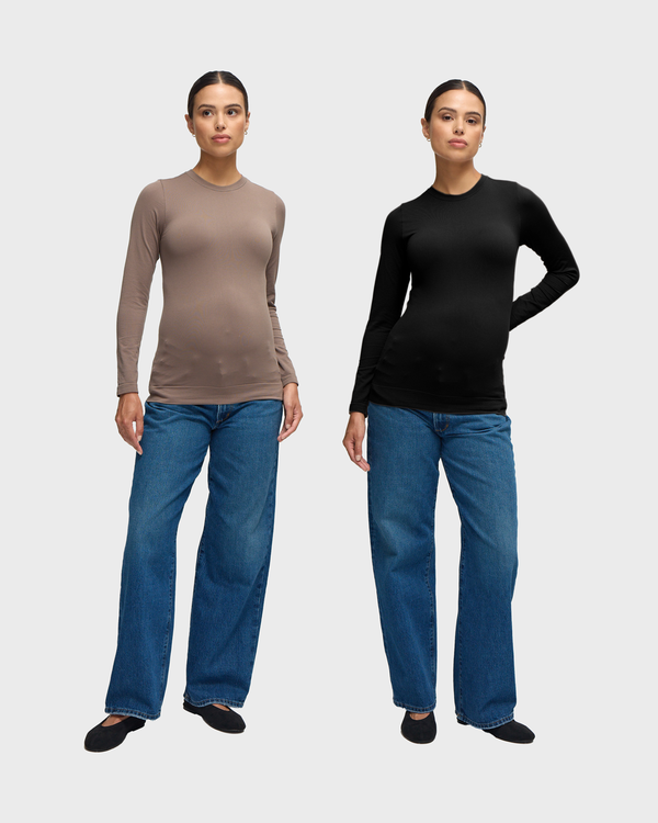 ||Two pregnant woman, one wearing black and the other taupe seamless maternity rib long sleeve crew tee with blue jeans and black ballerina flats